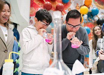 Open house attendees participating in science demonstration