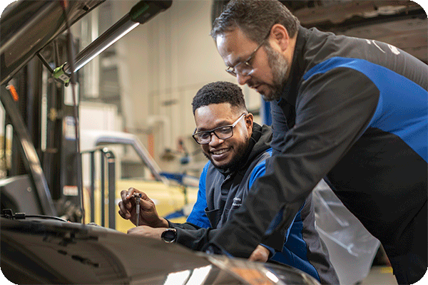 Students working under hood of car