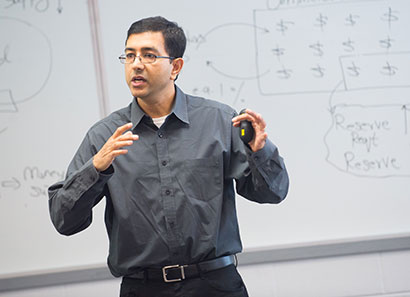 Business faculty teaching in front of a white board