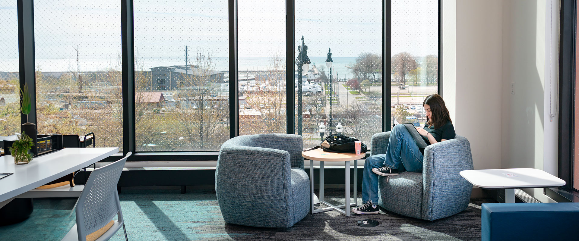 Student studying at CLC Lakeshore Campus with views of Lake Michigan in distance