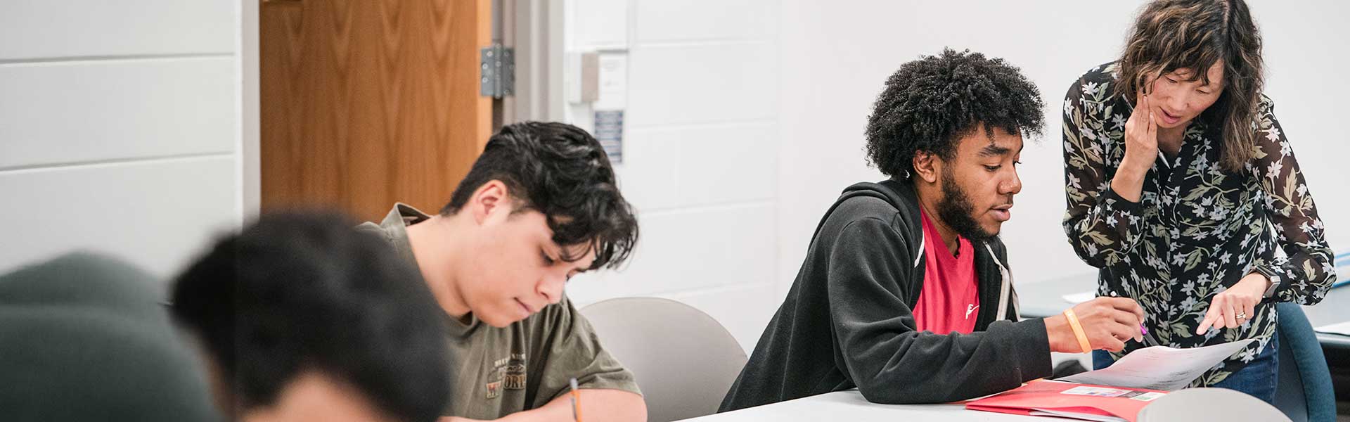 Student getting help from instructor in math class