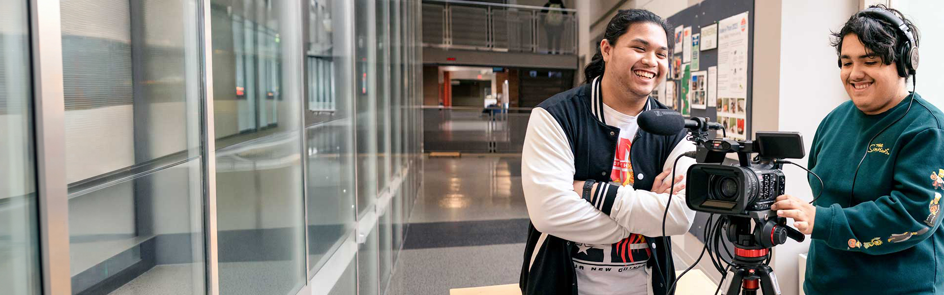 Digital Media and Design students with video equipment in campus hallway