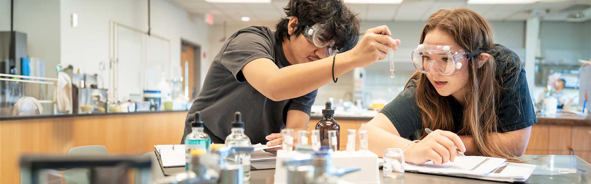 Two students working on experiment in chemistry lab