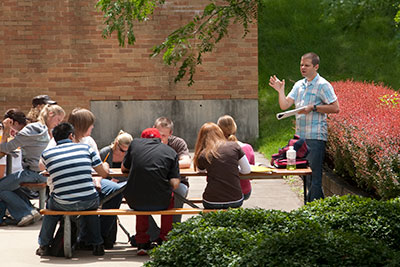 Instructor leading class of students outdoors