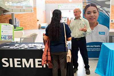 Student talking to Siemens rep during campus job fair