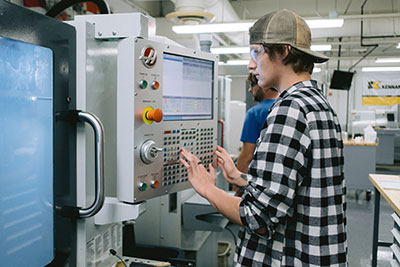 Student programming a CNC machine