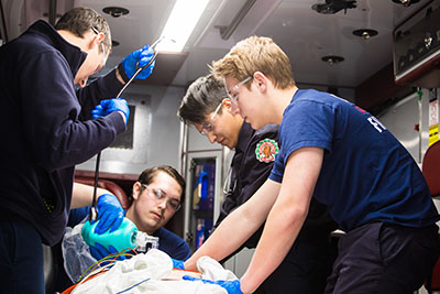 Several students practicing EMT skills in an ambulance