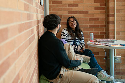 Two students talk at a corner table