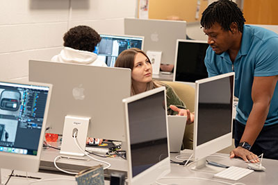 Student gets instruction from instruction in computer lab
