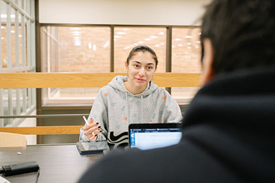 Two students sitting across from each other having a discussion