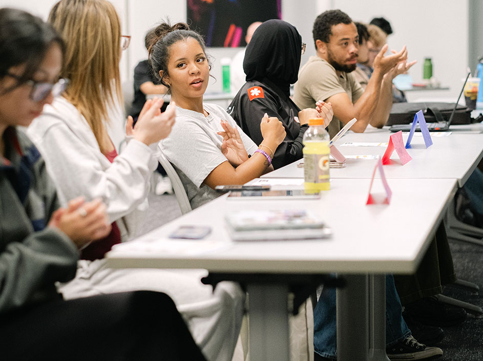 Students sitting at long table, talking