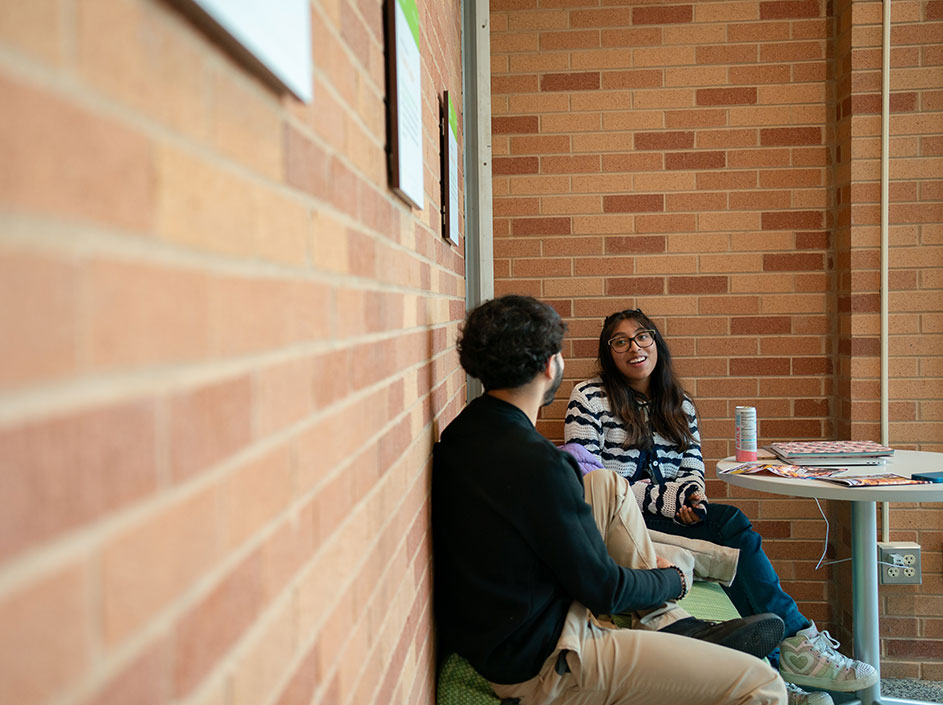 Two students talking in a corner on campus