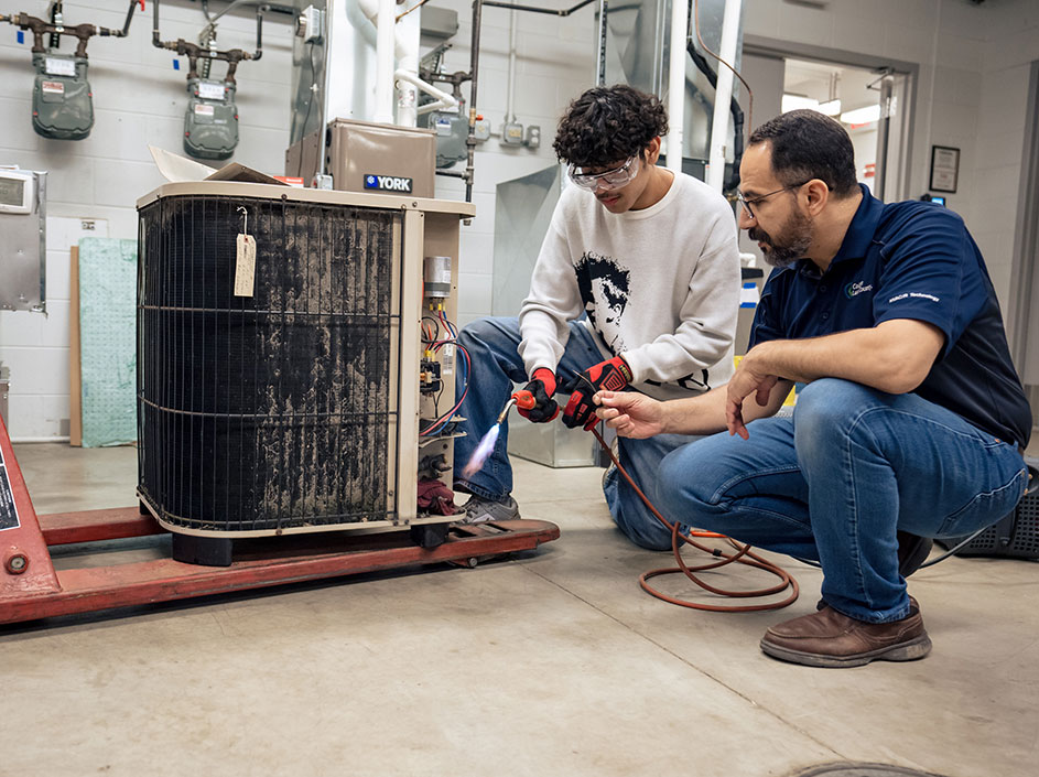 Student learning hands-on HVAC skills with guidance from instructor