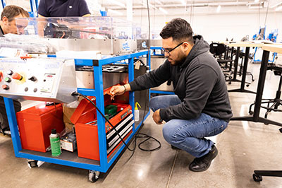 Student gets part from a toolbox in the Industrial Technology Lab.