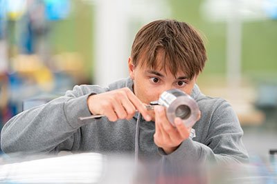 Student using tools to measure part