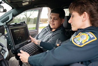 Police apprentice sittin in police car