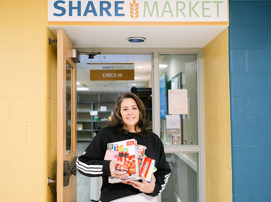 Student holding food items in front of SHARE Market entrance