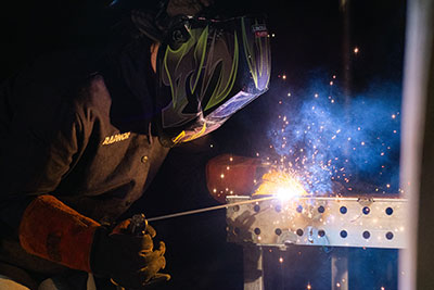 Welding student practicing skills in welding lab