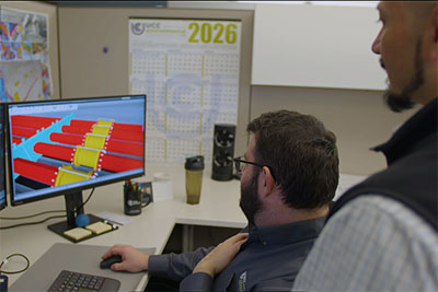 Travis Taylor at his computer at UCC, with Juan Martinez in foreground