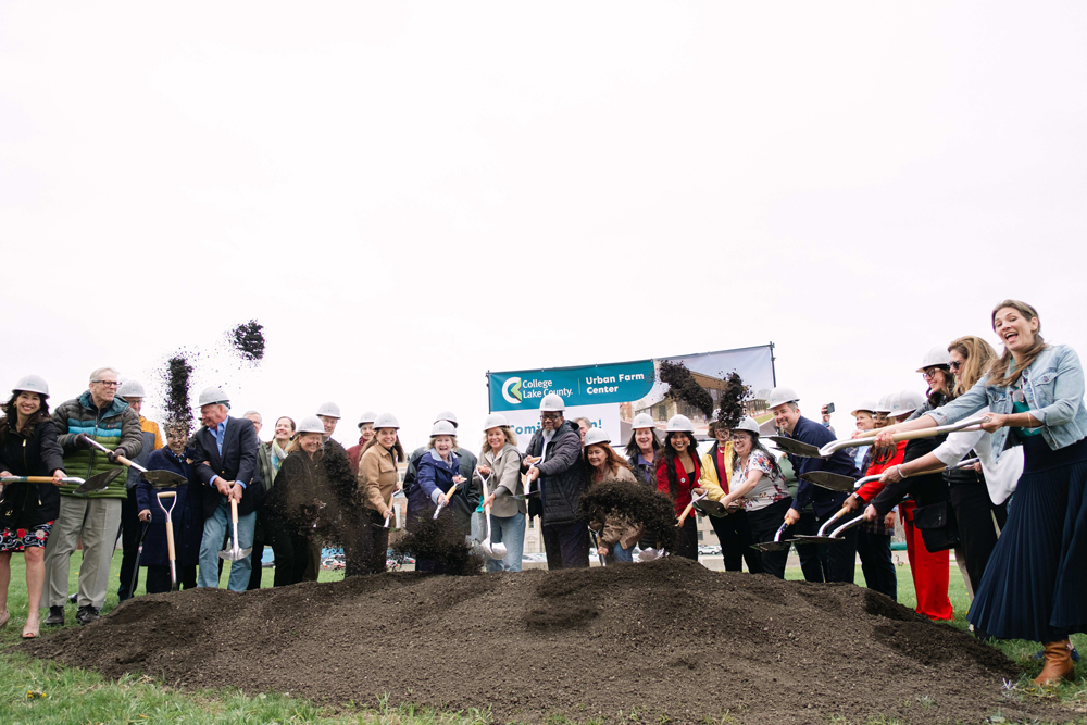 CLC community members shoveling dirt to celebrate the Urban Farm Center's groundbreaking ceremony