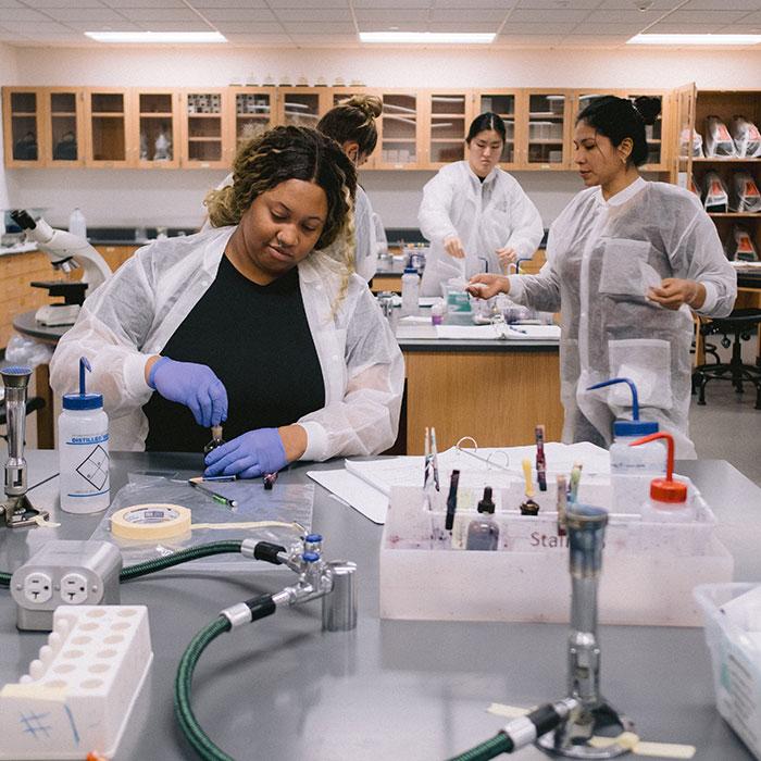 Students performing lab techniques in the CLC biology lab