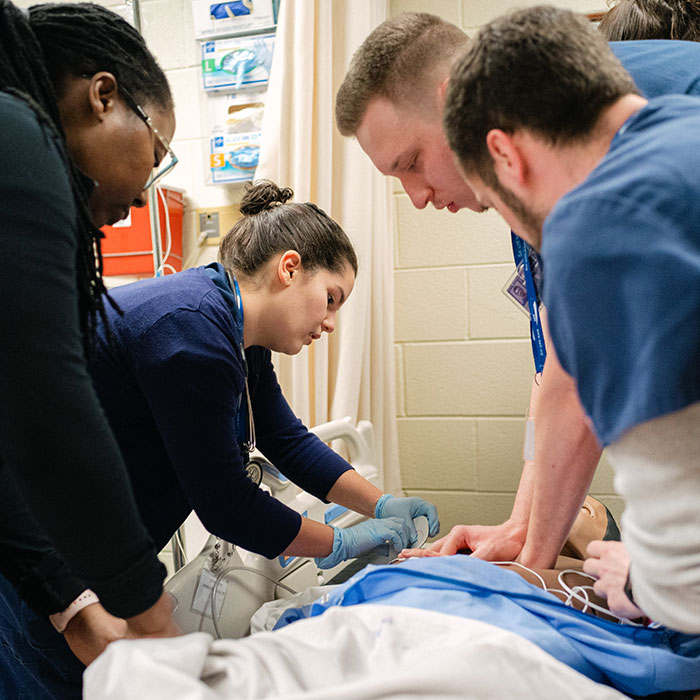 Nursing students learning hands-on in the simulation lab