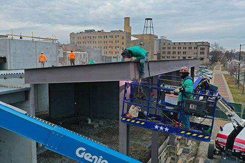 Construction workers on the roof of the new Urban Farm Center